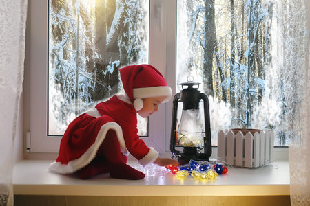 A child in the new year looks out the window. Children are waitiの写真素材