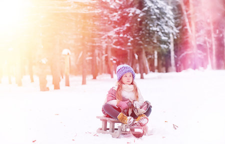 A winter fairy tale, a young mother and her daughter ride a sled