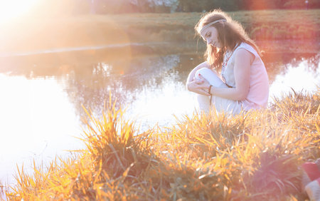 A girl on a walk in a park. Young red-haired girl in the springの写真素材