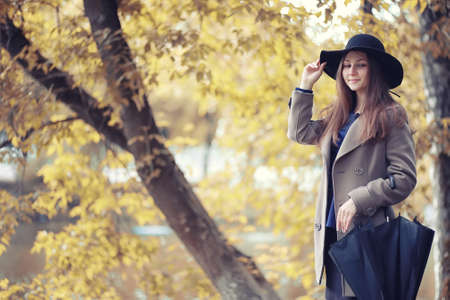 Young girl in a coat in autumn  parkの写真素材