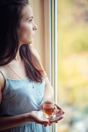A girl at the window in the houseの写真素材