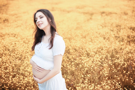Pregnant woman in nature for a walk in the autumn