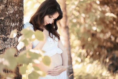 Pregnant woman in nature for a walk in the autumnの写真素材
