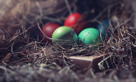 Easter painted eggs on burlap and straw.の写真素材