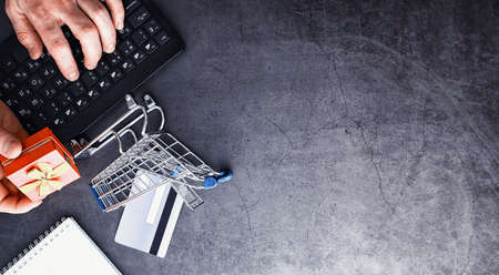 Shopping concept. Supermarket trolley, money and gifts on the background.の写真素材