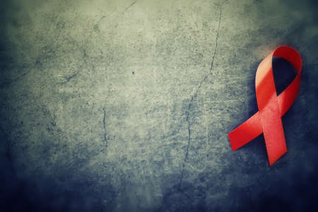 Symbol of human immunodeficiency virus disease. Red ribbon. A helping hand and support. Background.の写真素材