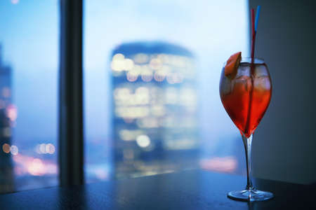 Cocktail glasses on the windowsill by the glass of a tall buildingの写真素材