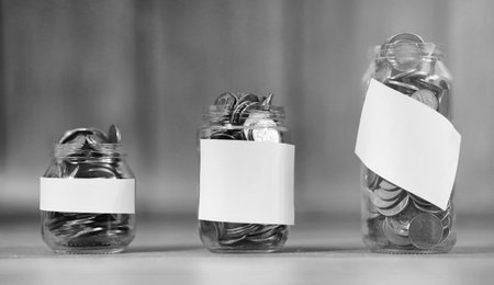 Coins in a jar on the floor. Accumulated coins on the floor. Pocket savings in piles.の写真素材