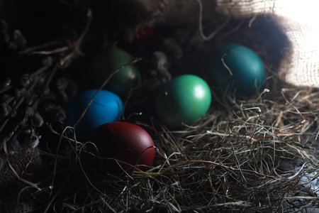 Easter painted eggs on burlap and strawの写真素材