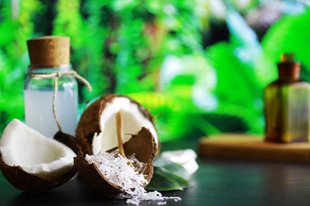 Coconut on a dark stone table. Coconut oil and chips.の写真素材