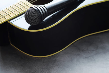 Guitar and accessories on a stone background. Desk musician, headphones, microphone and more.の写真素材