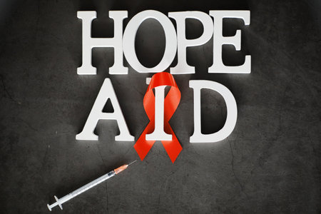 Symbol of human immunodeficiency virus disease. Red ribbon. A helping hand and support. Background.の写真素材
