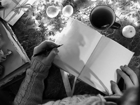 a man with a blank book in his hands for the New Year's table with decorationsの写真素材
