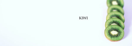 A kiwi fruit is sliced into pieces on a white background