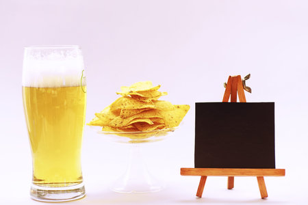 A stack of vintage books and a mug of light beer on the tableの写真素材