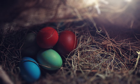 Easter painted eggs on burlap and strawの写真素材