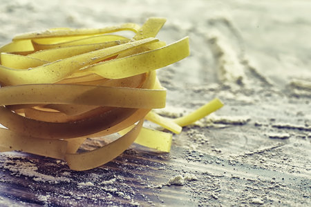 Pasta uncooked on the table. Noodles in the form of nests. Flour and seasonings.の写真素材