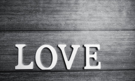 the word love made up of white wooden letters on a wooden backgroundの写真素材