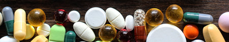 Medical background of various colorful medications on a textured wooden