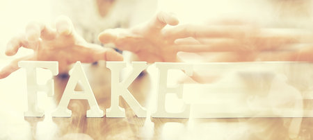 The letters spelled the word fake. The concept of modern information technology. Fake and facts in news.の写真素材