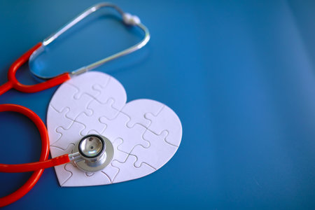 Doctor at his desk in the clinic's office. Stethoscope, test tubes, laptop, prescriptions, glasses on table.の写真素材