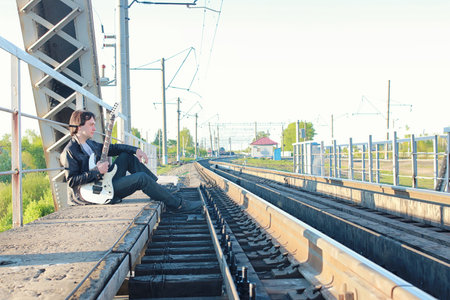 a man with an electric guitar in the industrial landscape outdoorsの写真素材