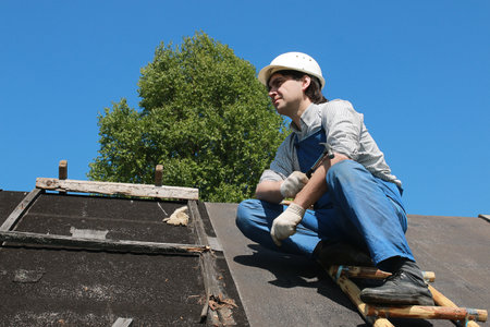 a man in the form of a builder repairs a houseの写真素材