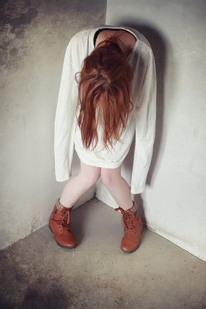 Young girl tied up on the floor. The girl sits on the floor with tied hands.の写真素材