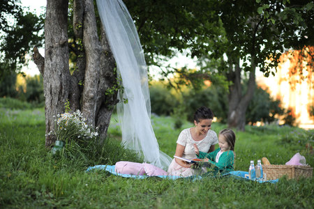 young mother with her daughter at a picnic in the parkの写真素材