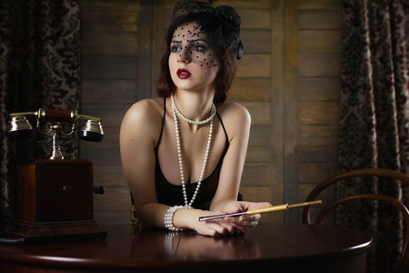 Beautiful 1930s girl at the tableの写真素材