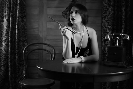 Beautiful 1930s girl at the tableの写真素材