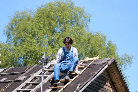a man in the form of a builder repairs a houseの写真素材