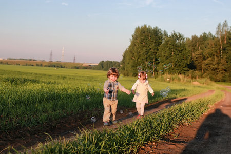 Children outdoors on nature in the grass fieldの写真素材