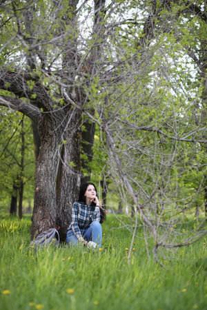 A girl in jeans and a hat travels the summer in the countryの写真素材