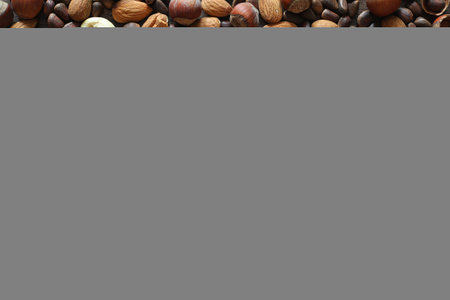 Different nuts on a wooden table. Cedar, cashew, hazelnut, walnuts and a spoon on the table. Many nuts are inshell and cleaned on a wooden backgroundの写真素材