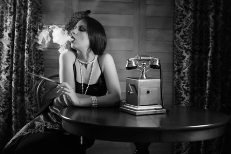 Beautiful 1930s girl at the tableの写真素材