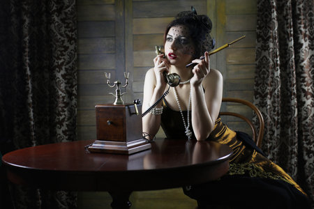 Beautiful 1930s girl at the tableの写真素材