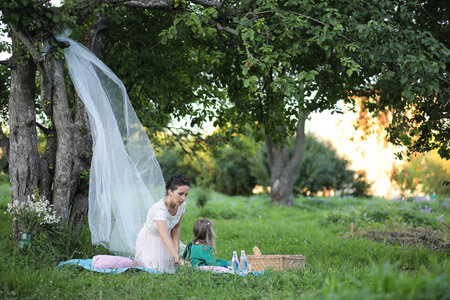 young mother with her daughter at a picnic in the parkの写真素材
