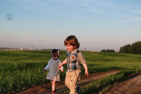 Children outdoors on nature in the grass fieldの写真素材