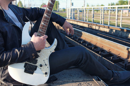 a man with an electric guitar in the industrial landscape outdoorsの写真素材