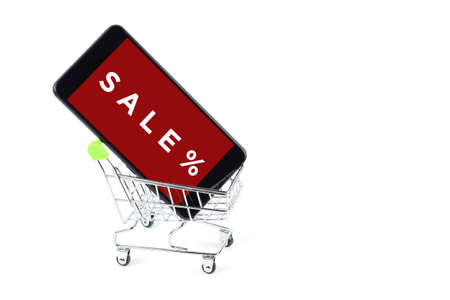 Smatrfon in a shopping trolley with the inscription SALE, isolate on white.の写真素材
