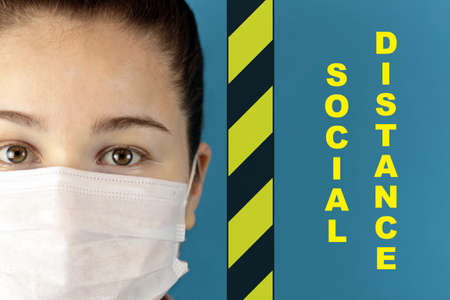The face of the doctor in a protective mask, signal tape and text "social distance"の写真素材