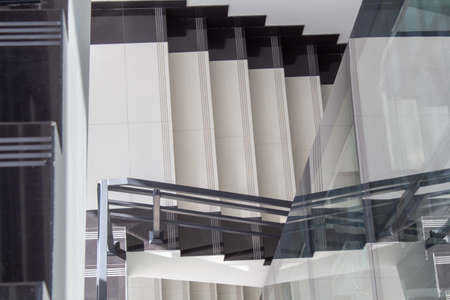The staircase of the office building and a fragment of the glass elevator shaft.の写真素材