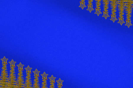 Stars on the tops of the Christmas tree, located on opposite corners of the blue background.の写真素材