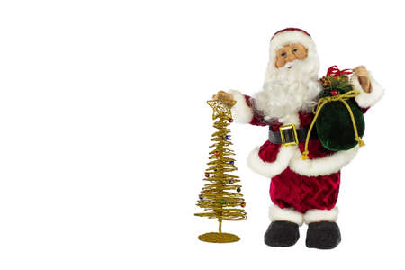 Santa Claus in a red suit and a big bag of gifts with a golden Christmas tree on a white background, place for text.の写真素材