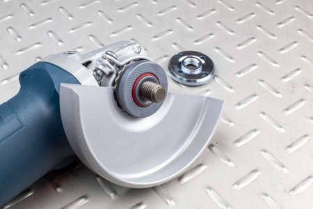 Fragment of an electric grinding machine, a central shaft with nuts for fixing grinding discs.の写真素材