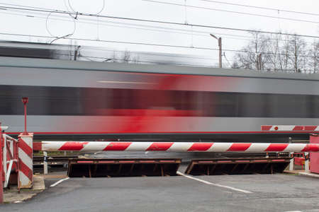A clear electric train against the background of a closed barrier, road safety.の写真素材