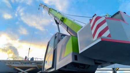 The boom of a tower truck crane against a blue sky.の写真素材