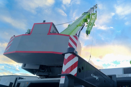 The boom of a tower truck crane against a blue sky.の写真素材
