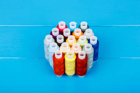 Spools of thread, lying on a blue wooden background.の写真素材